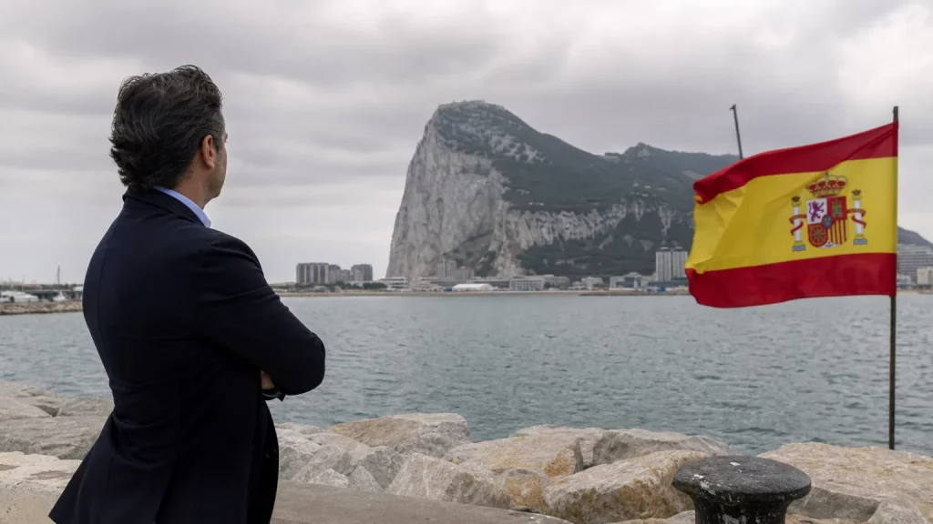 Un empresario español observa la costa de Gibraltar con una bandera de España al viento