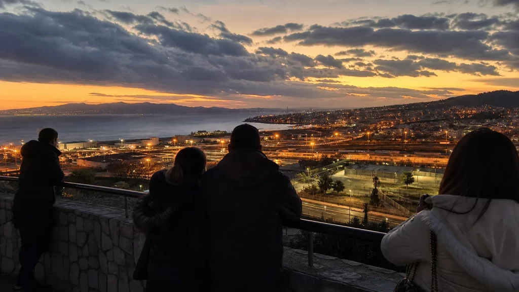Vista de la ciudad de Ceuta con la frontera de fondo, mientras personas de espaldas observan la situación con preocupación.
