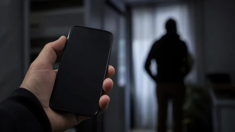 Silueta de una persona con un teléfono móvil, superpuesta con un mapa de Marruecos y España, en un contexto de espionaje digital.