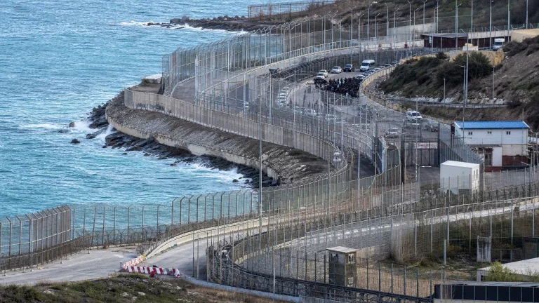 Silueta de una figura militar de alto rango de espaldas mirando un gran mapa de España con Ceuta y Melilla resaltadas, en un entorno de oficina sobrio y profesional que sugiere seguridad nacional.