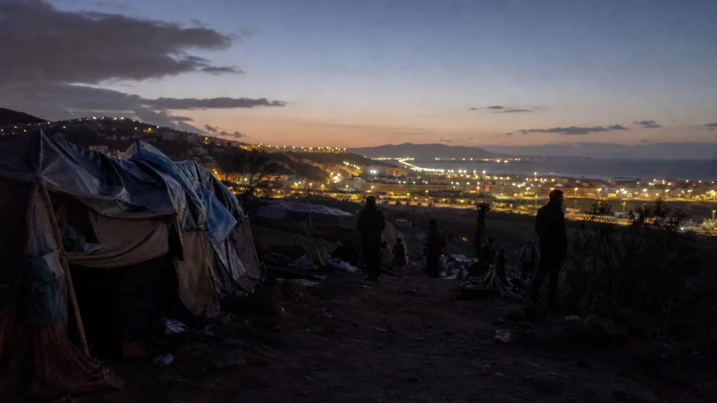 Siluetas de personas en un barranco oscuro al anochecer, con una sensación de desolación y gritos lejanos que se pierden en la distancia, evocando la vulnerabilidad de las víctimas en Ceuta.